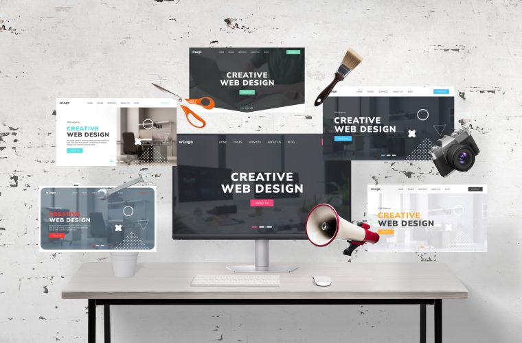 Web pages flying around a web designer's desk and computer display featuring an agency web page presentation. Includes web designer tools: megaphone, wrench key, photo camera, scissors, and brush